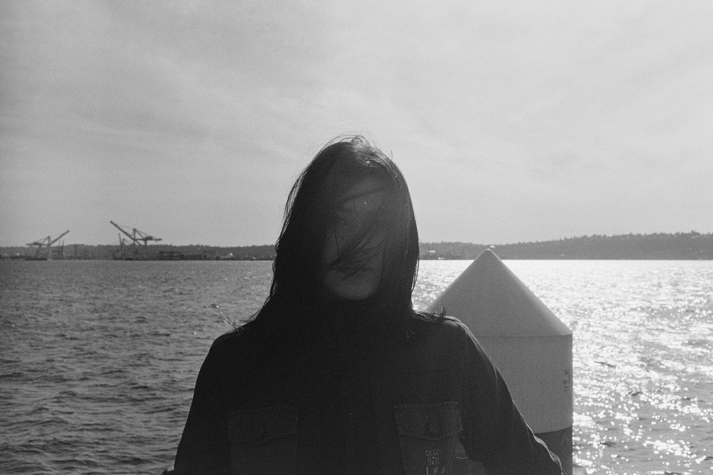 Hair across the face, wind off the water