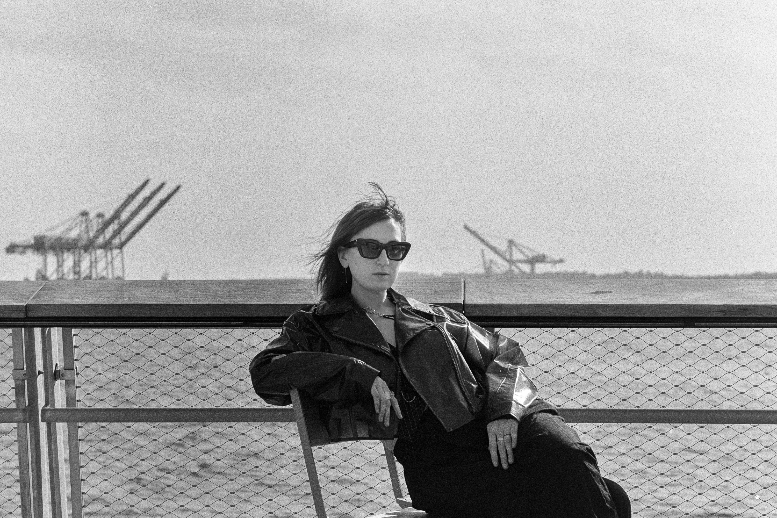 Seated at the rail, cranes on the horizon