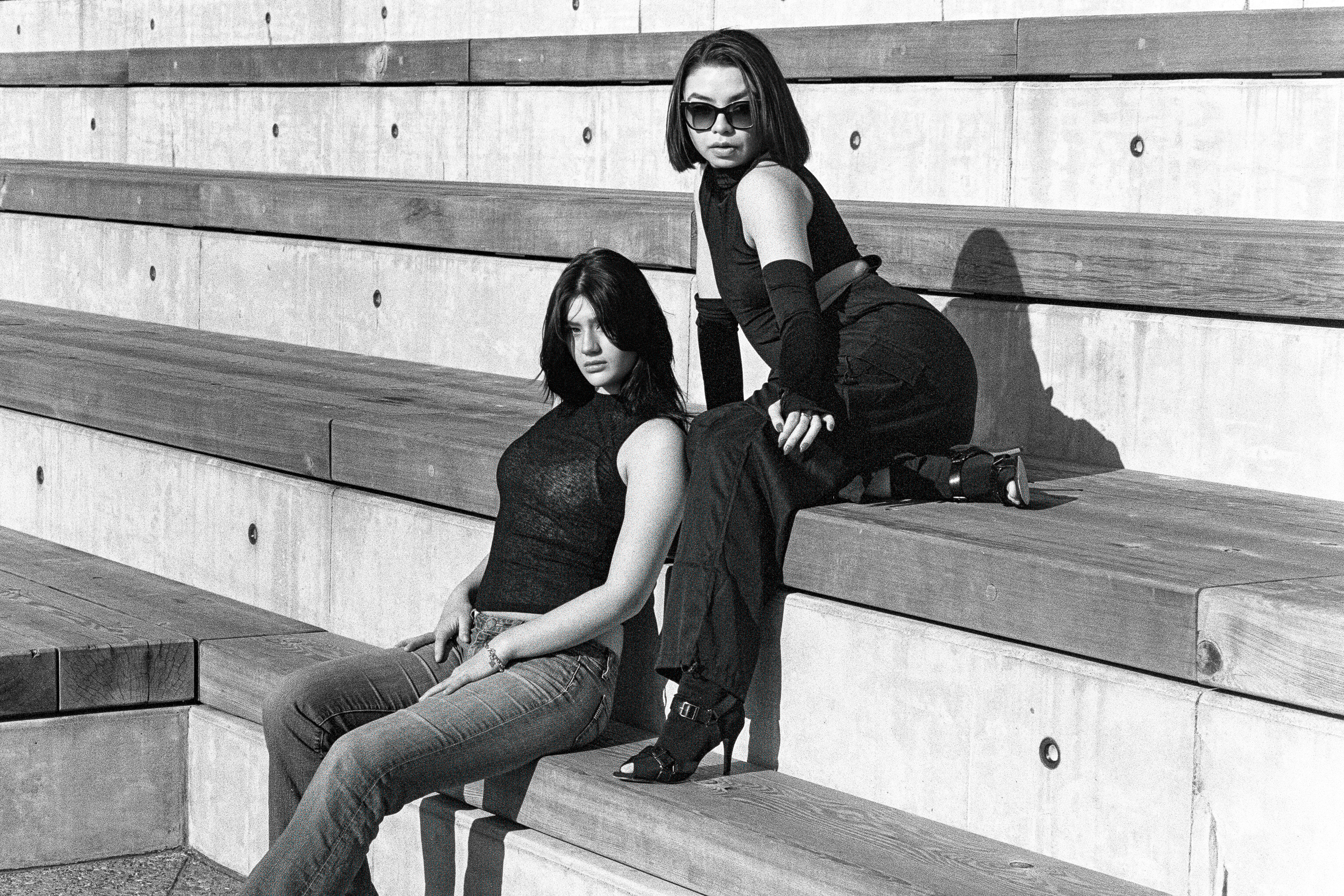 Two models seated on the bleacher edge